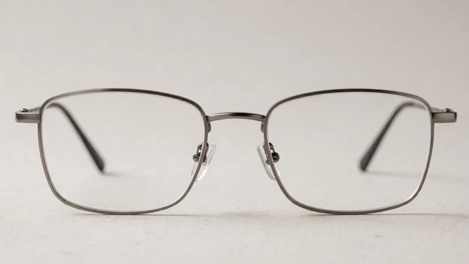 The front of the gunmetal titanium rectangle frame, photographed straight on against pale grey stone.