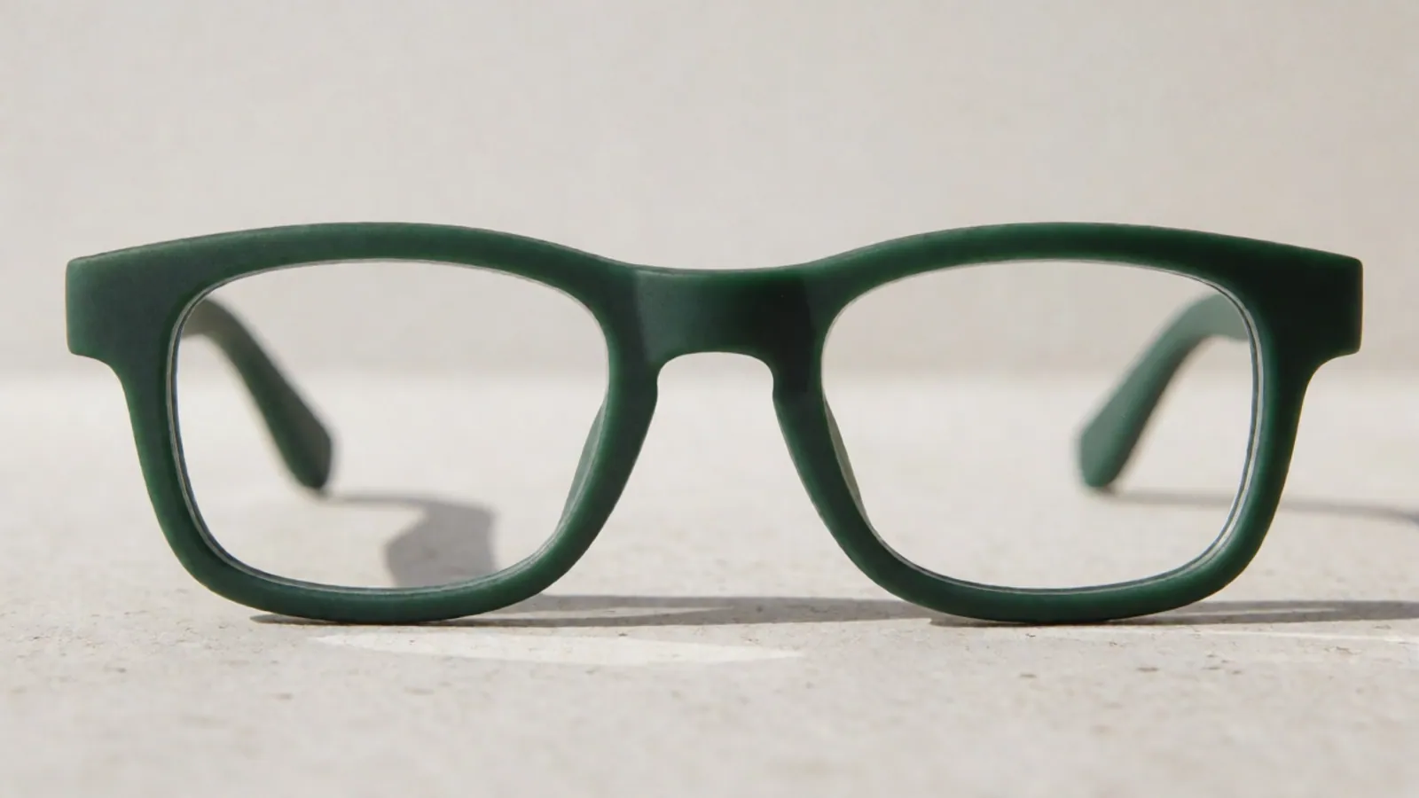 The front of the forest green flexible nylon rectangle frame, photographed straight on against pale grey stone.