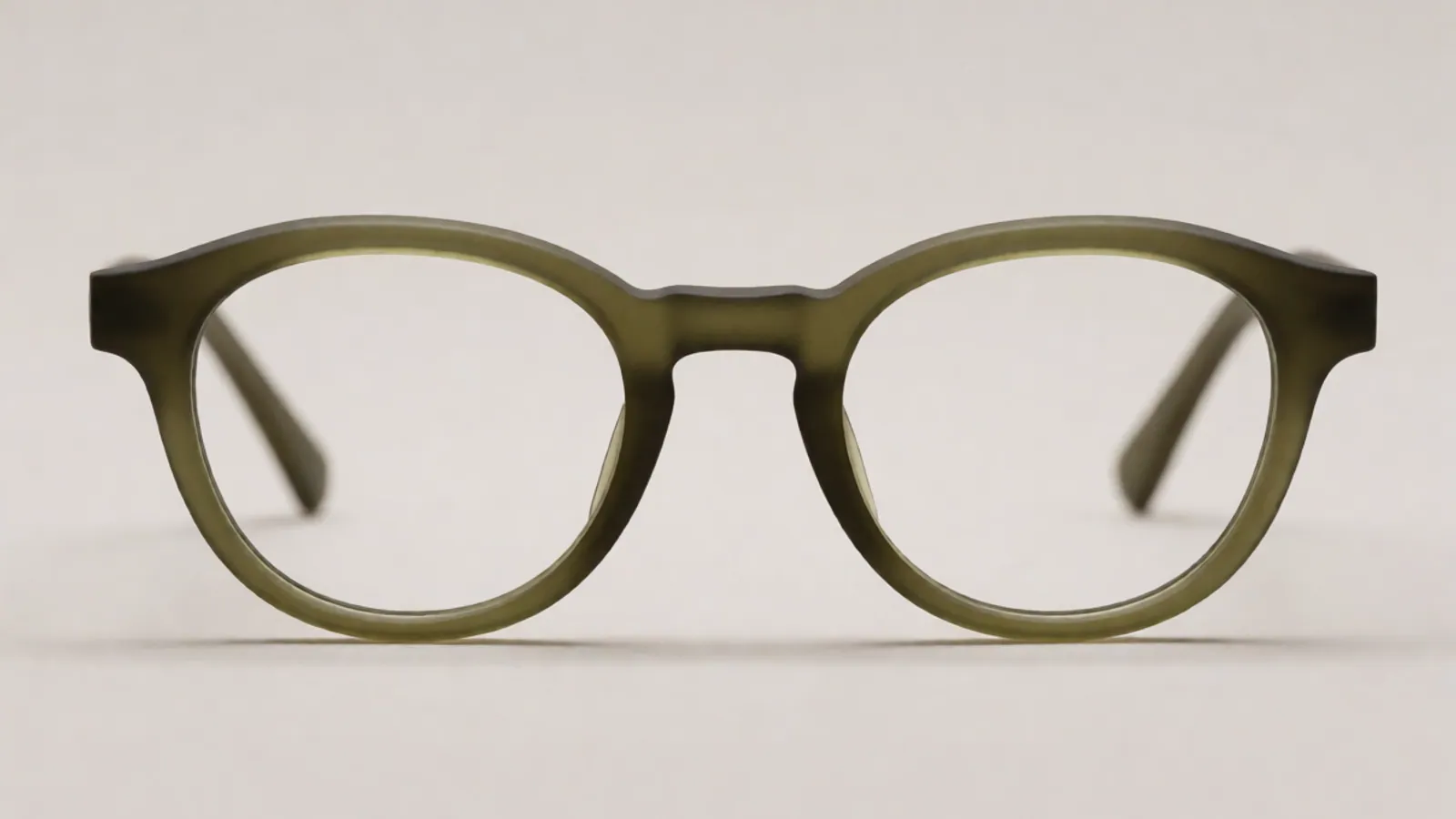 The front of the matte olive acetate oval frame, photographed straight on against pale grey stone.
