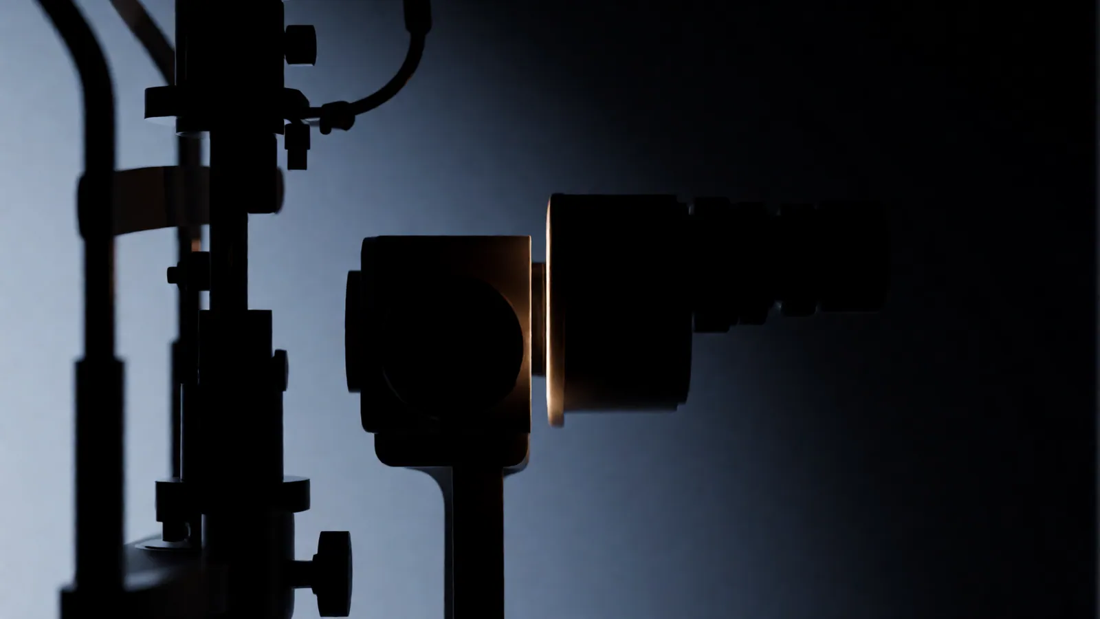 A slit lamp microscope in profile as a dark silhouette, a thin blade of warm light crossing the frame